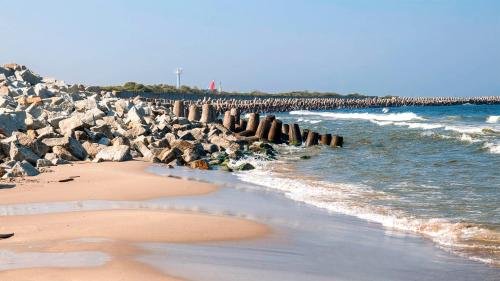 a beach with a large group of rocks and the ocean at SOBIESZEPTY Odetchnij ciszą in Gdańsk
