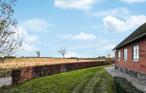 a brick building and a field next to a building at Lovely Home In Skivarp With Wifi in Skivarp