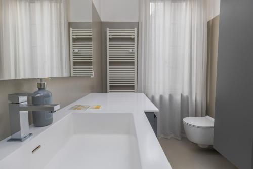 a white bathroom with a sink and a toilet at Kramer House-Porta Venezia-5min to Duomo in Milan