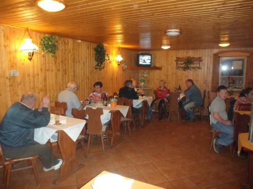 a group of people sitting at tables in a restaurant at Pension Mikulka in Mikulov v Krušných Horách