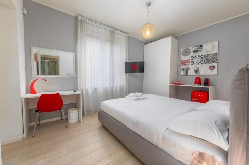 a bedroom with a bed and a desk and a red chair at Kramer House-Porta Venezia-5min to Duomo in Milan