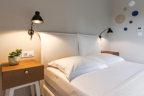 a bedroom with a white bed with a wooden night stand at Topos Villas in Parga