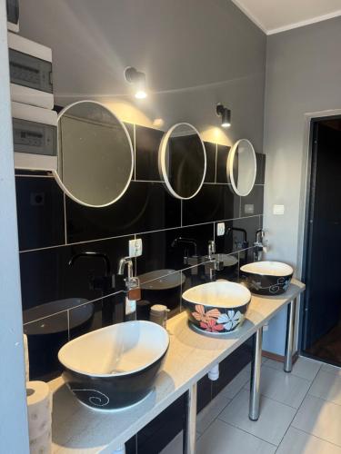 a bathroom with two sinks and two mirrors at Noclegi pod Kurzą Górą in Kurzętnik
