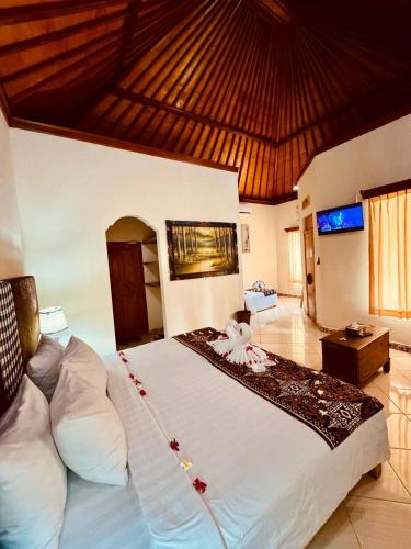 a bedroom with a large white bed in a room at Bungalow Geringsing in Candidasa