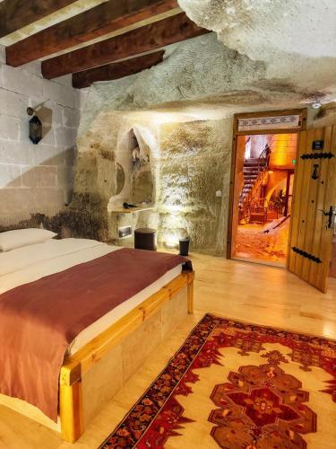 a bedroom with a large bed in a stone room at My Cave Suites in Nevsehir