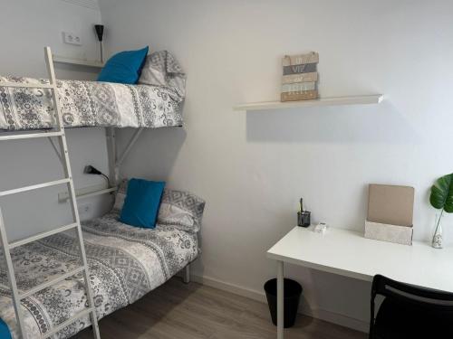 a dorm room with a desk and a bunk bed at Apartamento Vega in Baena