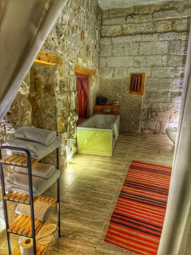 a stone bathroom with a tub and a sink at My Cave Suites in Nevsehir
