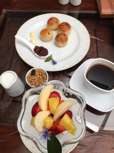 a table with two plates of food and a cup of coffee at Roka Plaza Hotel Boutique in Ambato