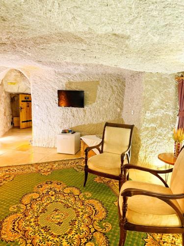 a living room with two chairs and a tv in a building at My Cave Suites in Nevsehir