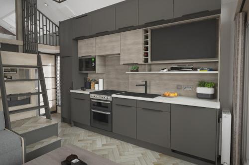 a kitchen with a sink and a stove at Sandaway Holiday Park in Combe Martin