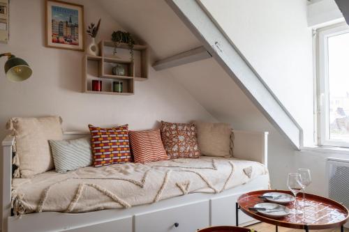a living room with a couch with pillows on it at Le cocon de la gare in Rennes