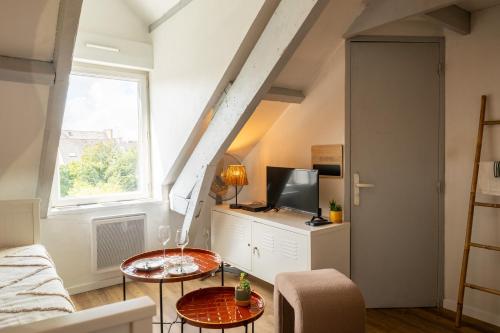 a living room with a couch and a tv at Le cocon de la gare in Rennes