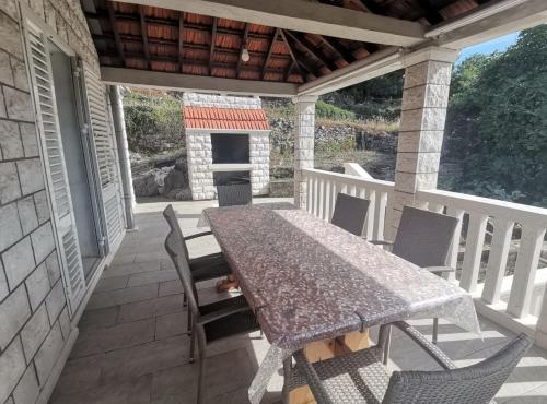 a table and chairs on a porch with a fireplace at Perfect Getaway Near Korčula’s Scenic Sights and Beaches in Žrnovo