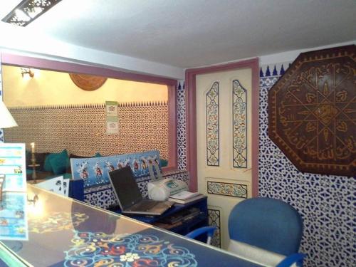 an office with a desk with a laptop and a chair at Hôtel Riad Gnaoua in Essaouira