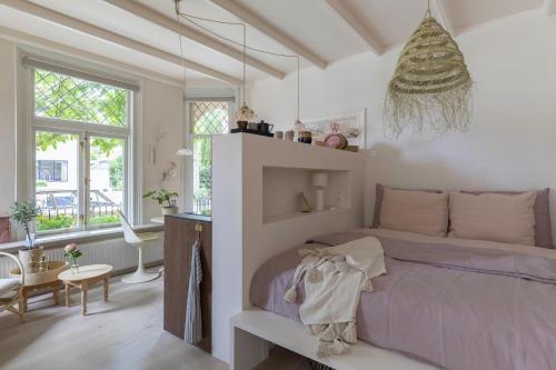 une chambre avec un lit violet dans une pièce avec des fenêtres dans l'établissement Villa Magnolia, à Bergen