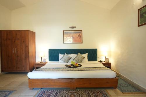 a bedroom with a bed with a bowl of fruit on it at Astroport Sariska Treetop by Eight Continents in Tehla