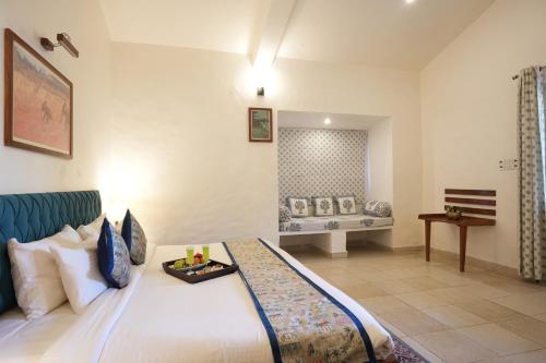 a bedroom with a bed with a tray on it at Astroport Sariska Treetop by Eight Continents in Tehla