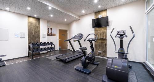 a gym with treadmills and elliptical machines at PLAZA INN Stuttgart-Ditzingen in Ditzingen