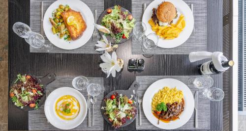 a table topped with plates of food and french fries at PLAZA INN Stuttgart-Ditzingen in Ditzingen