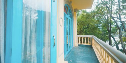 a balcony of a house with a blue door at Bhagvatam by the Ganges in Shivpuri