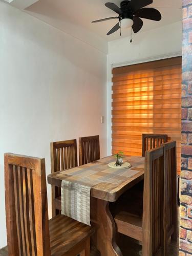 a dining room table with chairs and a ceiling fan at Travelers Hub 1 Camella Tarlac in Tarlac