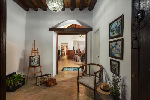 a hallway of a house with a chair and a doorway at Oinoessa Traditional Boutique Guest Houses in Lofou