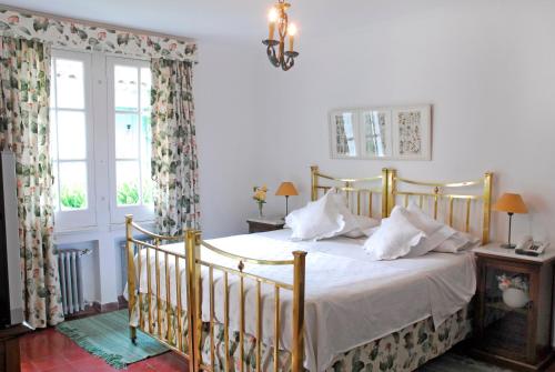 a bedroom with a bed with white sheets and pillows at Estancia Ave María in Tandil