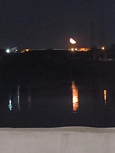 a view of the water at night with lights at Noupian mother in Aswan