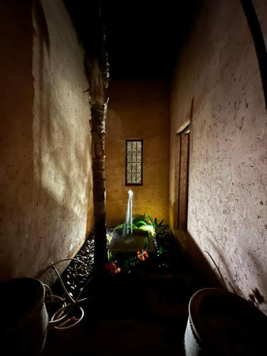 a dark hallway with a fountain in a building at Villa kasbah de luxe, piscine et jacuzzi chauffés, jardin tropical in Marrakech