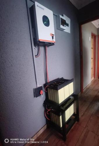 a room with two lights and a tv on the wall at Fresh Ideas GuestHouse in Soshanguve