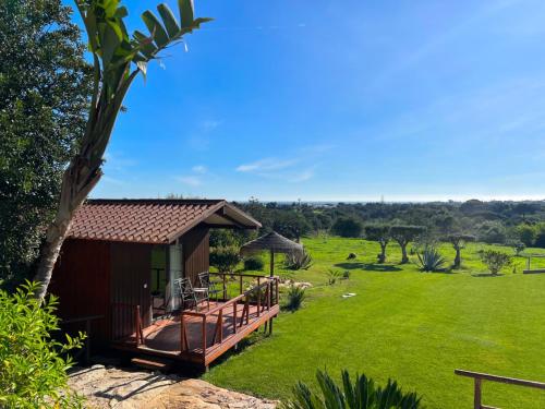a house with a deck and a grass field at Quinta Saleiro Guesthouse in Olhão