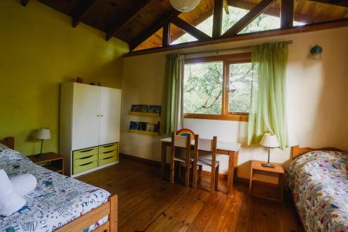 a bedroom with a desk and a bed and a table at Hermosa Casa cerca del Teleférico Cerro Otto in San Carlos de Bariloche