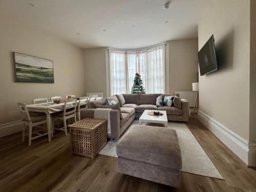 a living room with a couch and a table with a christmas tree at Spacious 4-Bed Apartment In City Centre in Brighton & Hove