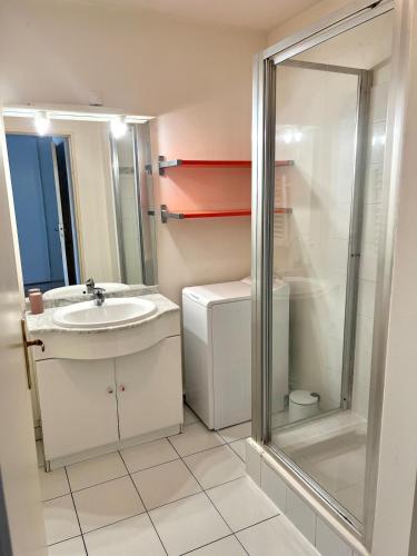 une salle de bain avec un lavabo et une douche dans l'établissement Le Corsaire - Appartement spacieux avec terrasse, à Aytré
