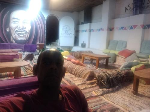 a man sitting on a couch in a living room at Noupian mother in Aswan