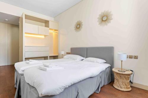 a bedroom with a large bed with white sheets at The João I Collection Two Bedroom in Lisbon