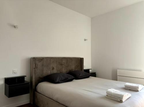 une chambre avec un lit avec deux serviettes dessus dans l'établissement L'Escapade Marcquoise, à Marcq-en-Barœul