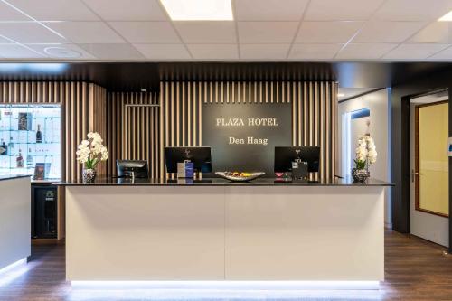 a hotel lobby with a reception counter with flowers at PLAZA Premium Den Haag City Center in The Hague