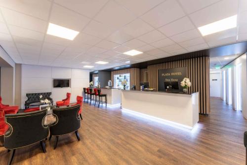 a waiting room with red chairs and a counter at PLAZA Premium Den Haag City Center in The Hague