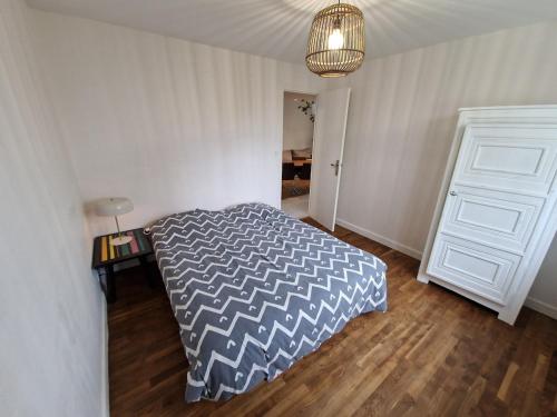 une chambre avec un lit et une table avec une lampe dans l'établissement Maison à deux pas de la mer, à Gâvres