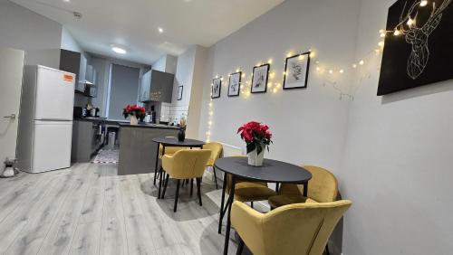 a kitchen and dining room with two tables and yellow chairs at Soho Guest House Room 2 in London