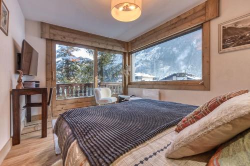 une chambre avec un lit et une grande fenêtre dans l'établissement Apt 8 pers hyper centre à Chamonix, à Chamonix-Mont-Blanc