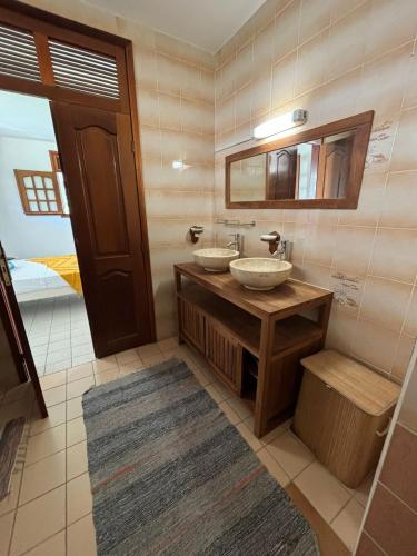 ein Badezimmer mit zwei Waschbecken und einem Spiegel in der Unterkunft L’Amandine in Sainte-Anne