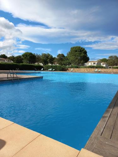 une grande piscine avec de l'eau bleue dans l'établissement Mini villa avec jardin Cala Rossa - Porto Vecchio, à Lecci