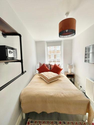 a bedroom with a bed with red pillows on it at Soho Guest House Room 2 in London