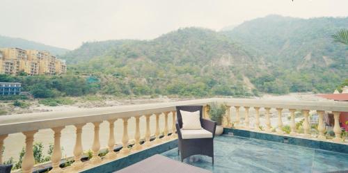 a balcony with a view of a river and mountains at Bhagvatam by the Ganges in Shivpuri