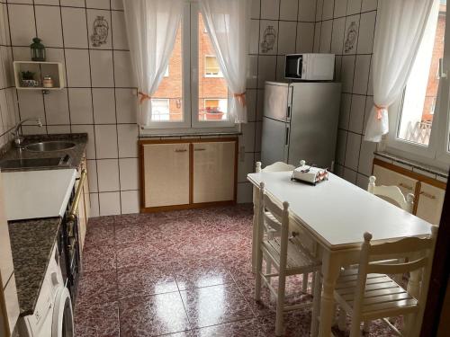 a kitchen with a table and a refrigerator at Apartamento en Sotrondio in Sotrondio