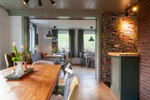 a dining room and living room with a wooden table at Forellenhof Wald- und Wiesenquartier in Bad Berleburg