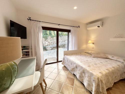 a bedroom with a bed and a large window at VILLA LA MARINA 5&1, Emma Villas in Porto Cervo