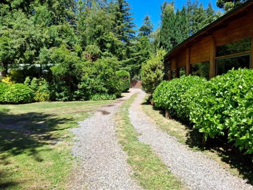 a gravel path next to a building with bushes at Cabanas Mapulauquen in Pucará